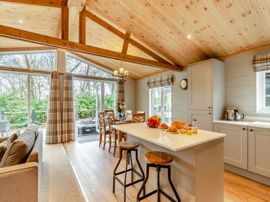 A kitchen with a dining area and sofa at Argel Spa Pet in Praze-An-Beeble