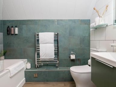 A bathroom with a bath, towel rail, sink and toilet at Kilden Pet in Praze-An-Beeble