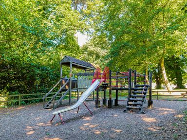 A playground with a slide and climbing frame at Lowarth Lodge Spa Pet, Praze-An-Beeble