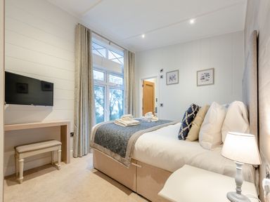 A bedroom with a bed and television at Milk Wood 2, Laugharne