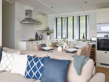 A kitchen with dining table and appliances at Milk Wood 2 Spa in Laugharne