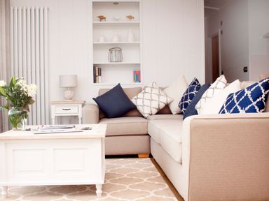 A living room with a sofa, coffee table, and lamp at Milk Wood 2 Spa in Laugharne