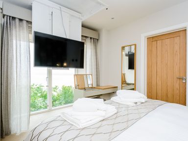 A bedroom with a bed, television, and mirror at The View in Laugharne