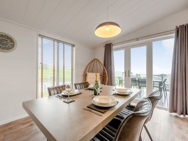 A dining room with a table set for dinner at Sonnet 2 Spa in Laugharne