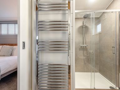 A bathroom with a shower and towel radiator at Sonnet 2 Spa in Laugharne