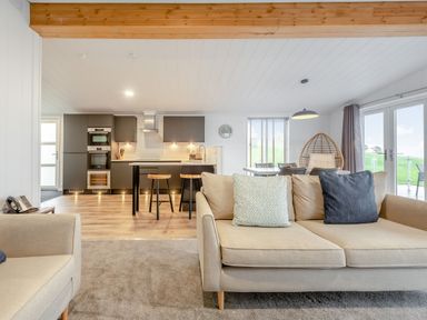 A living room with a kitchen and seating area at Sonnet 2 Spa in Laugharne