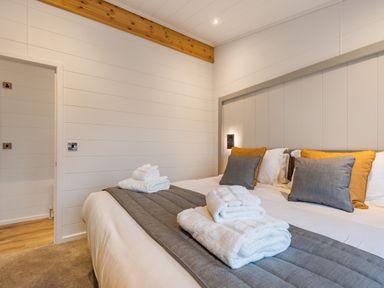 A bedroom with a bed and towels on it at Apex Spa in Laugharne