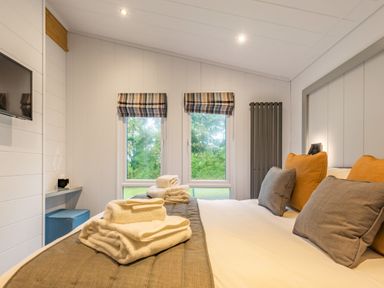 A bedroom with a bed and cushions at Apex Spa in Laugharne