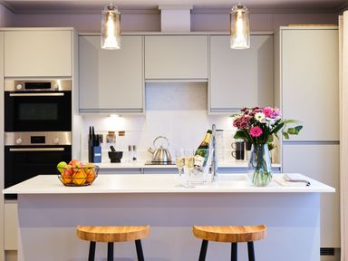 A kitchen with an island and bar stools at Epic Spa (Pet) in Laugharne