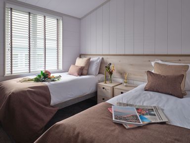 A bedroom with two beds and a nightstand at Epic Spa (Pet) in Laugharne