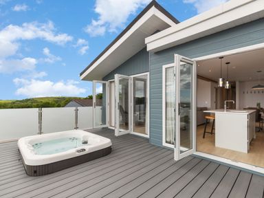 An outdoor area with a hot tub and sliding doors at Epic Spa (Pet) in Laugharne