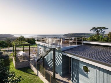 A house with a deck and staircase overlooking a landscape at Epic Spa (Pet) Laugharne