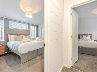 A bedroom with two beds and windows at Sonnet 3 Laugharne