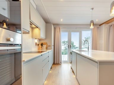 A kitchen with a sliding door and island at Epic Spa (Roof Terrace) in Laugharne