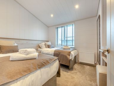 A bedroom with two beds and a window at Epic Spa (Roof Terrace) Laugharne
