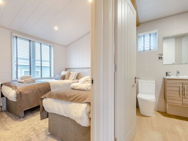 A bedroom with two beds and an adjoining bathroom at Epic Spa (Roof Terrace) in Laugharne