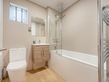 A bathroom with a toilet, sink, mirror, shower, and bathtub at Epic Spa (Roof Terrace) in Laugharne