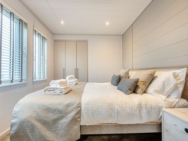 A bedroom with a bed and wardrobe at Epic Spa (Roof Terrace) Laugharne
