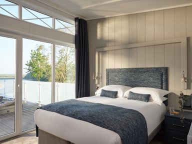 A bedroom with a bed and windows at Canto Spa in Laugharne