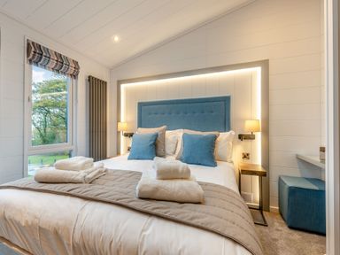 A bedroom with a bed and bedside table at Apex Spa (Pet) in Laugharne