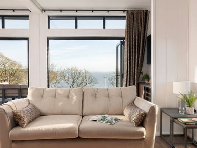 A living room with a sofa and a table at Solace in Laugharne