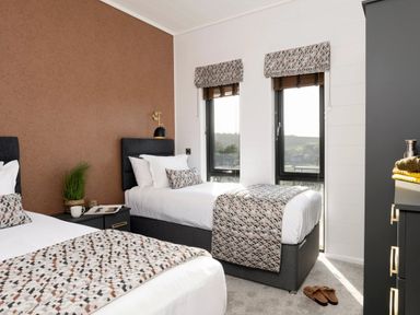 A bedroom with two beds and a small table at Solace in Laugharne