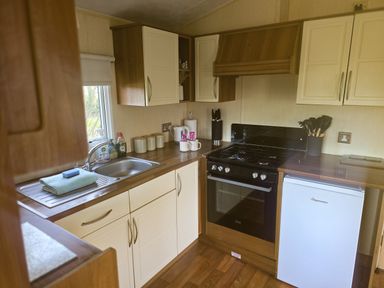 A kitchen with sink and stove at Caravan 1 at Blackmoor Farm near Tenby