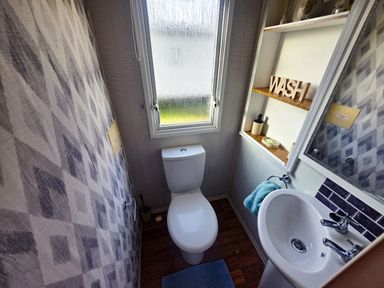 A bathroom with a toilet and sink at Caravan 1 at Blackmoor Farm near Tenby