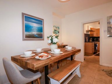A dining room with a wooden table and chairs at Chapel Cottage in Mevagissey