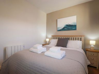 A bedroom with a bed and lamps at Chapel Cottage in Mevagissey