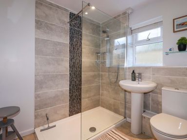 A bathroom with a shower, sink, and toilet at Chapel Cottage in Mevagissey