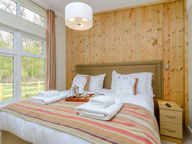 A bedroom with a bed and nightstand at The Fotheringhay (Pet) in Kings Cliffe