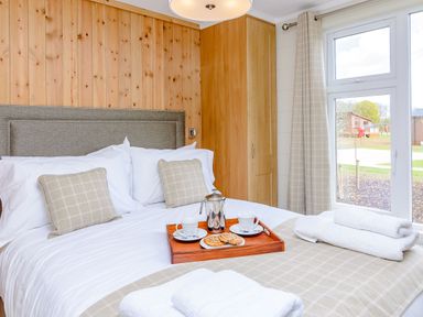 A bedroom with a bed, pillows, and a tray with coffee and cookies at The Alwalton (Pet) Kings Cliffe