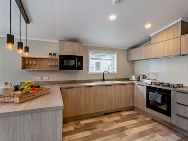 A kitchen with cabinets and appliances at Saron 2.0 Spa Pet in Llandyrnog
