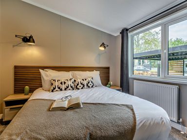A bedroom with a bed and bedside tables at Saron 2.0 Spa Pet in Llandyrnog