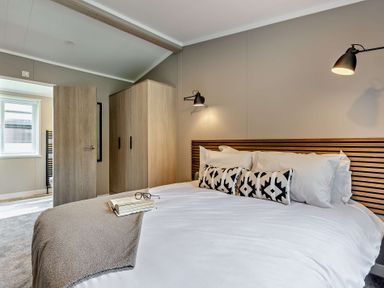 A bedroom with a bed and wardrobe at Saron 2.0 Spa Pet in Llandyrnog