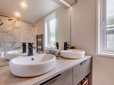 A bathroom with sinks and mirrors at Saron 2.0 Spa Pet in Llandyrnog