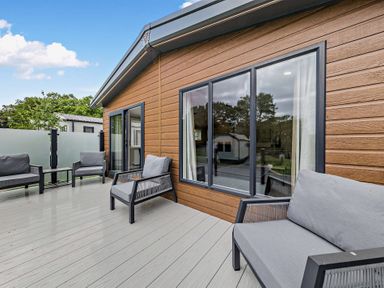 A deck area with chairs and large windows at Saron 2.0 Pet in Llandyrnog