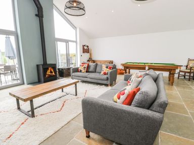 A living room with sofas and a fireplace at Cae Sam in Pentraeth