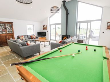 A living room with a pool table and seating area at Cae Sam in Pentraeth