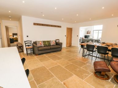 A living room with a sofa and dining table at Cae Sam in Pentraeth