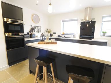 A kitchen with a kitchen island and appliances at Cae Sam in Pentraeth
