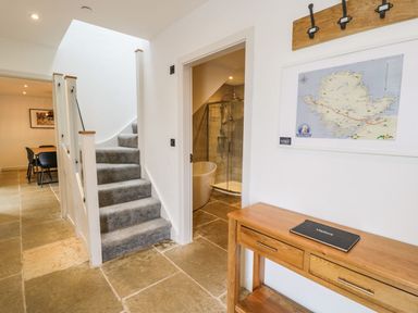 A hallway with a staircase and shower at Cae Sam in Pentraeth