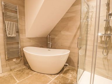 A bathroom with a bathtub and a shower at Cae Sam in Pentraeth