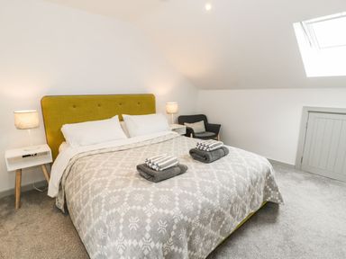 A bedroom with a bed and nightstands at Cae Sam in Pentraeth