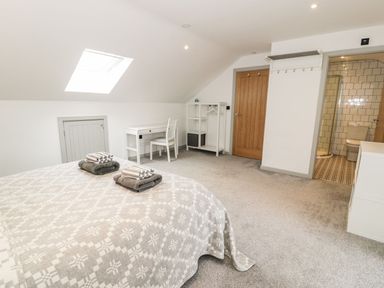 A bedroom with a bed and desk at Cae Sam Pentraeth