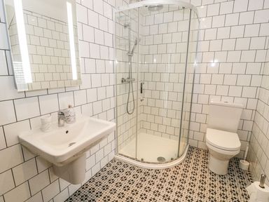 A bathroom with a shower, toilet and sink at Cae Sam in Pentraeth