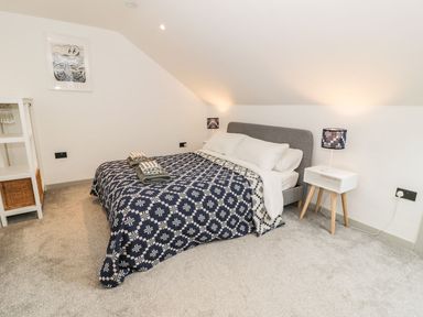 A bedroom with a bed and nightstand at Cae Sam in Pentraeth