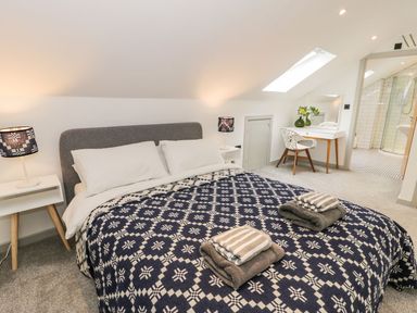A bedroom with a bed and desk at Cae Sam Pentraeth