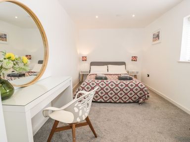 A bedroom with a bed and desk at Cae Sam in Pentraeth